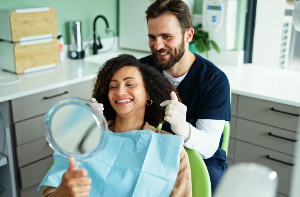 A dentist shows someone how clean their teeth can look and feel after going to the dentist.
