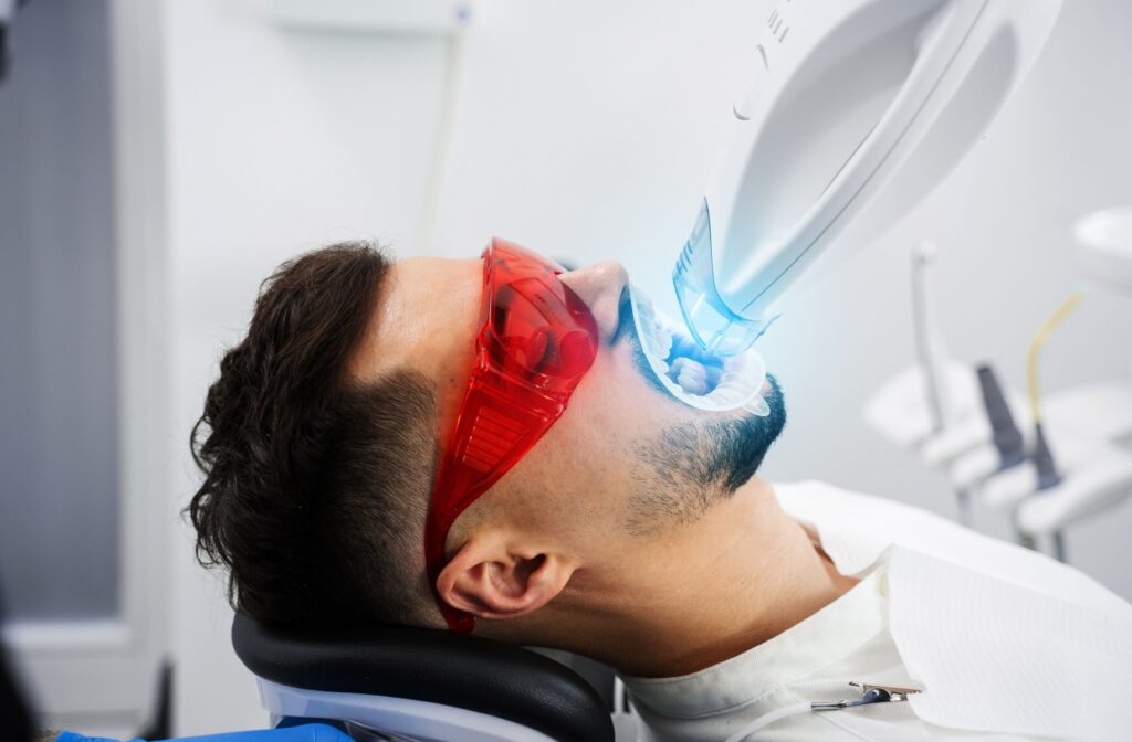Man undergoing professional teeth whitening treatment.